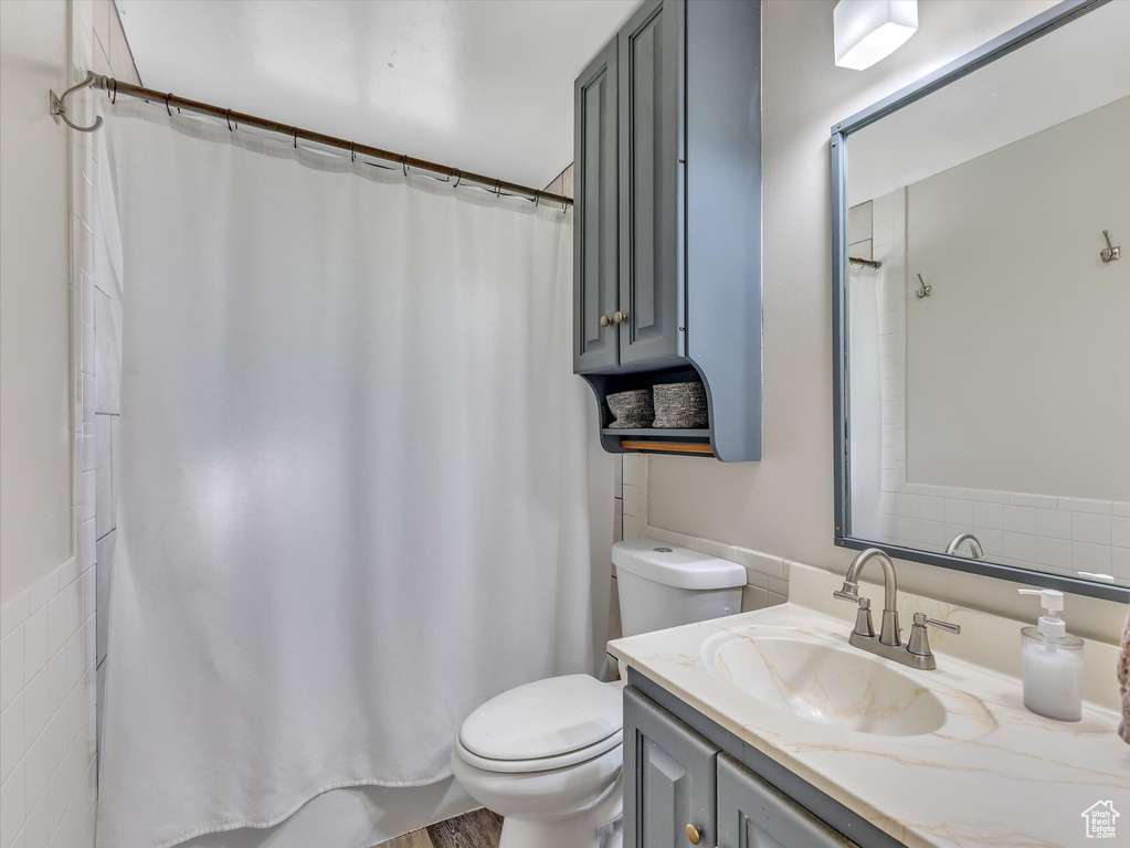 Bathroom with tile walls, toilet, and vanity