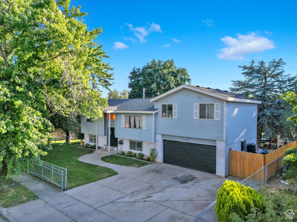 Split foyer home with a garage and a front lawn