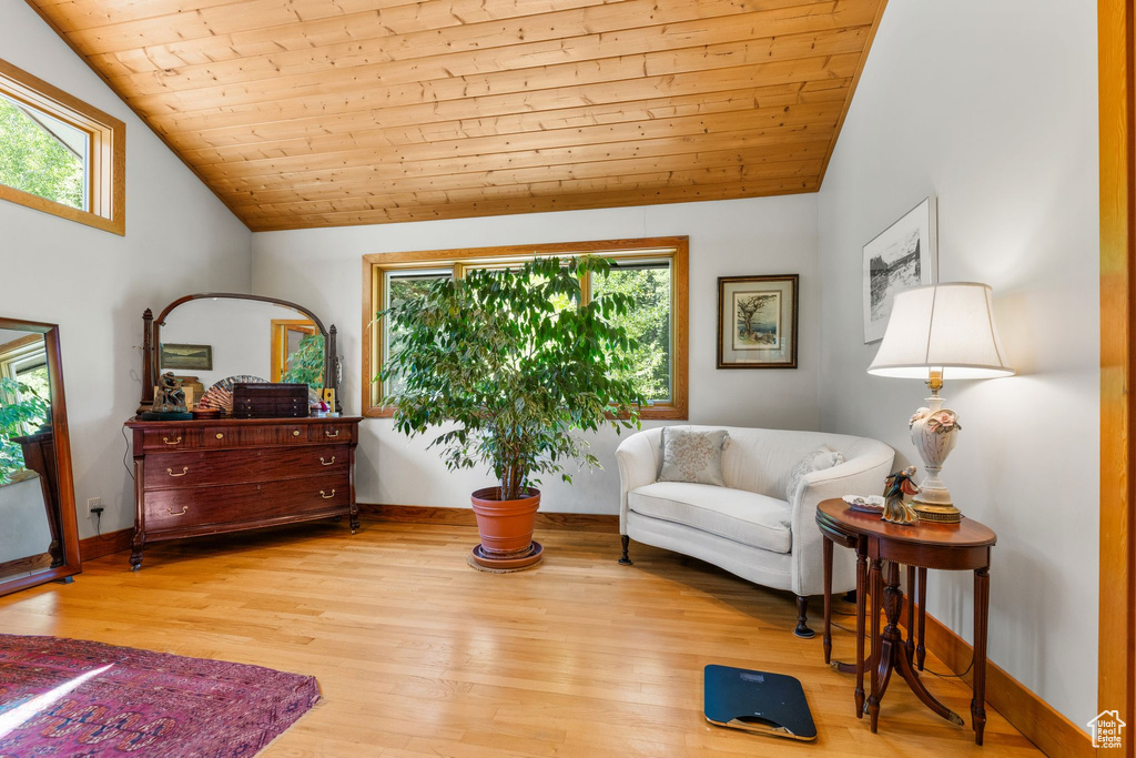 Living area with light hardwood / wood-style flooring, wood ceiling, and lofted ceiling