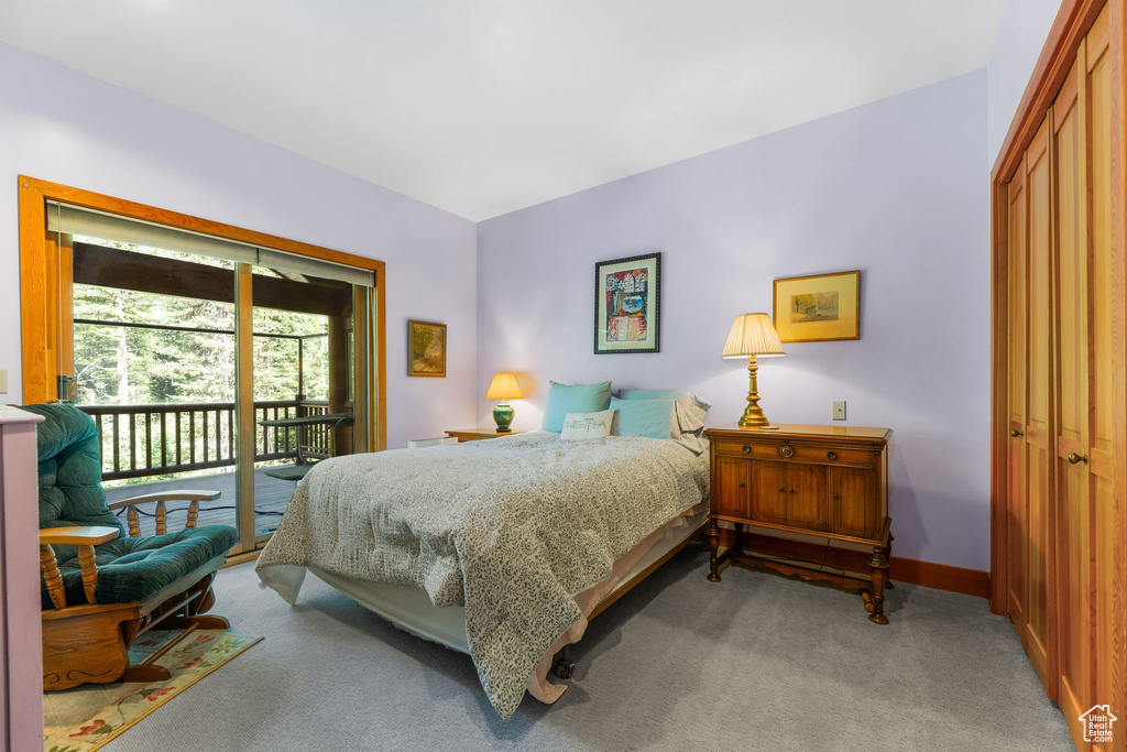 Carpeted bedroom with a closet and access to exterior