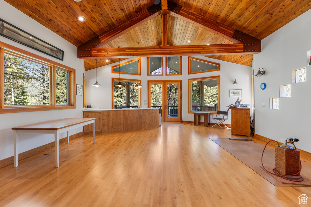Unfurnished living room with beam ceiling, wooden ceiling, and plenty of natural light