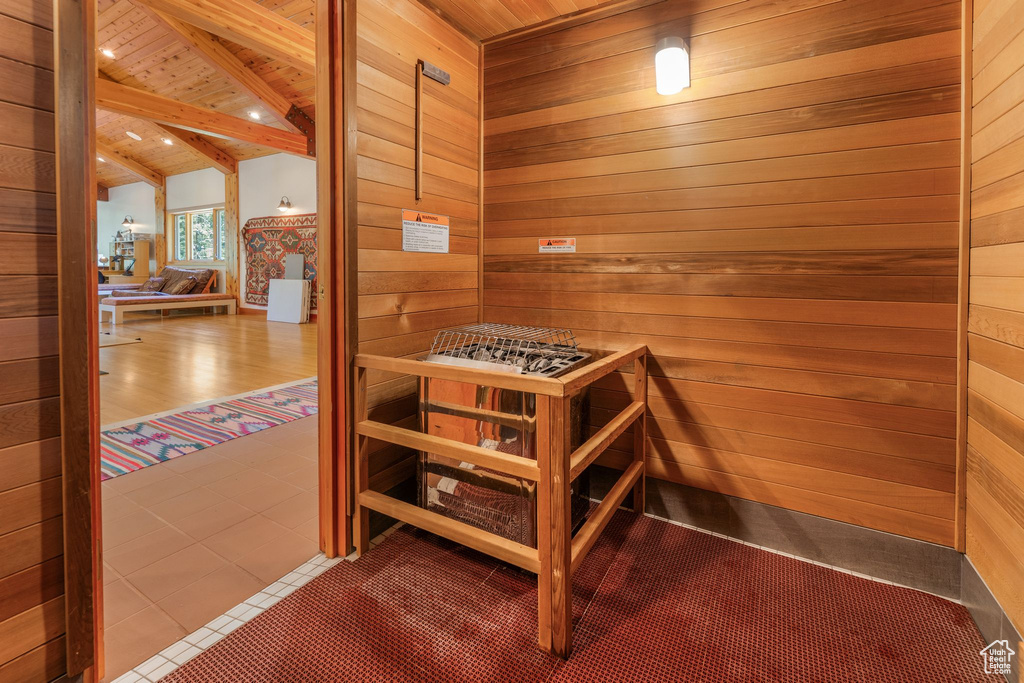 View of sauna with carpet flooring, wooden walls, and wood ceiling
