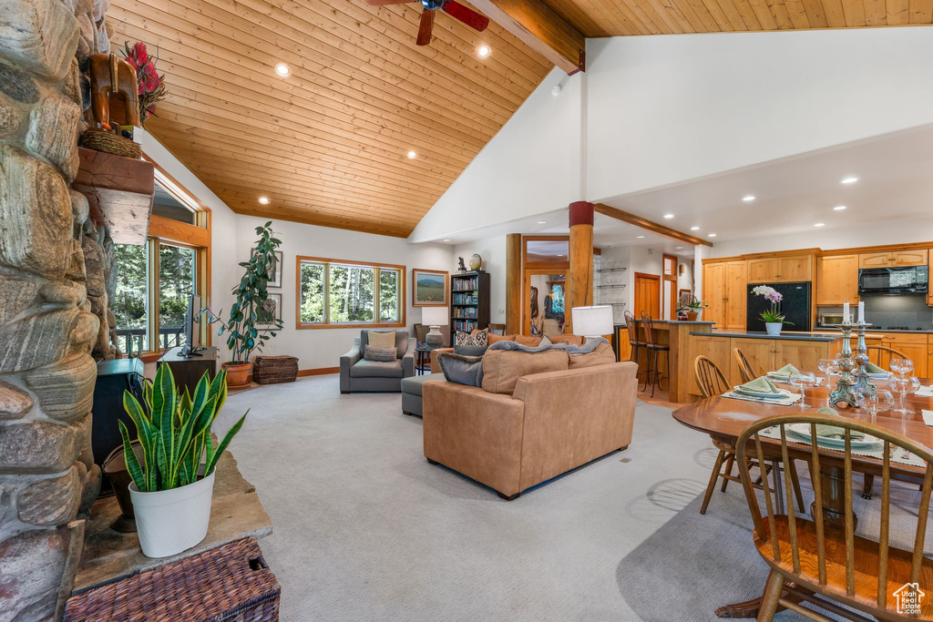 Living room with ceiling fan, light carpet, beamed ceiling, wood ceiling, and high vaulted ceiling