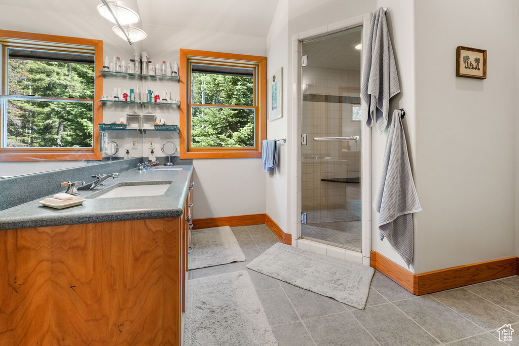 Bathroom featuring tile flooring, walk in shower, and large vanity