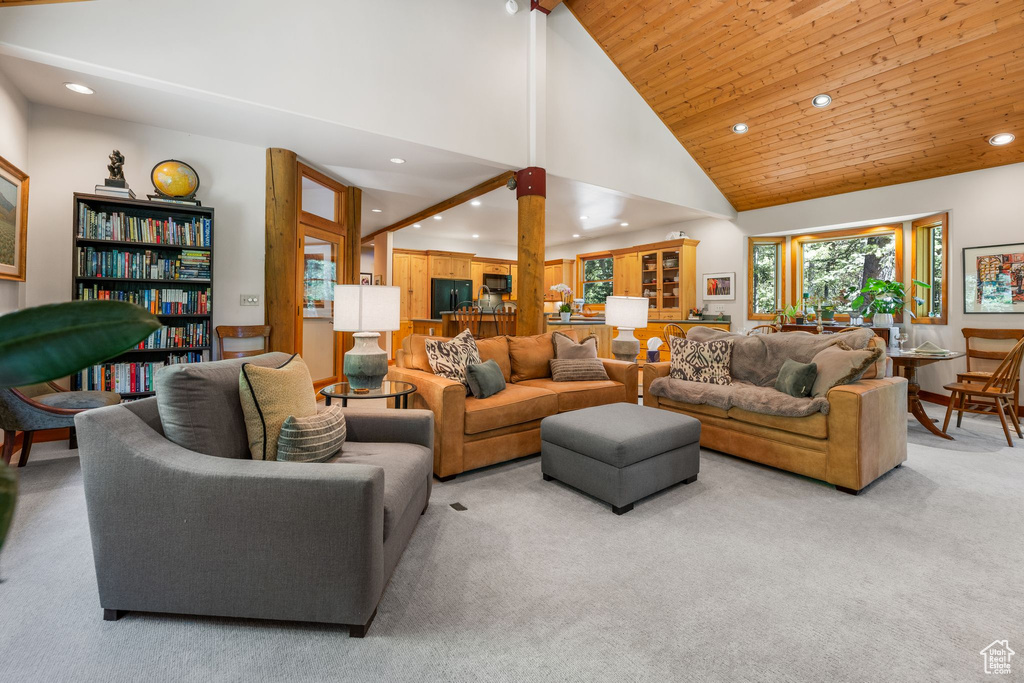 Carpeted living room featuring high vaulted ceiling and wooden ceiling