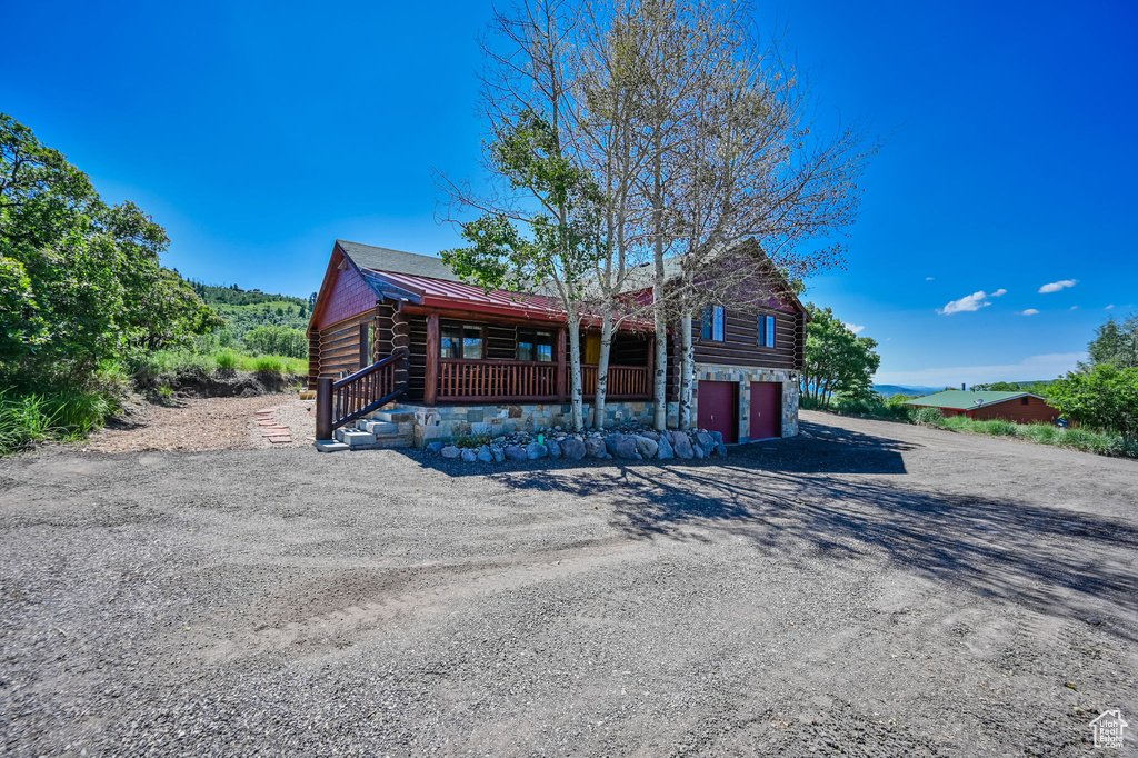 Log home with a garage and a porch