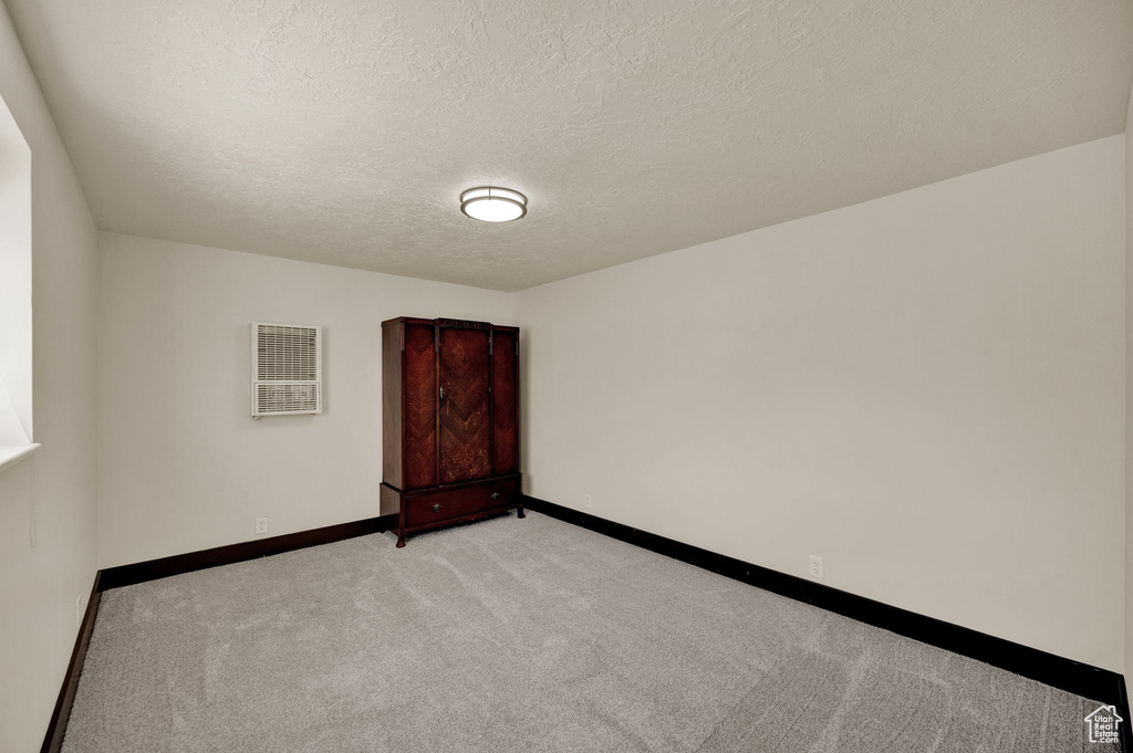 Carpeted empty room with a textured ceiling