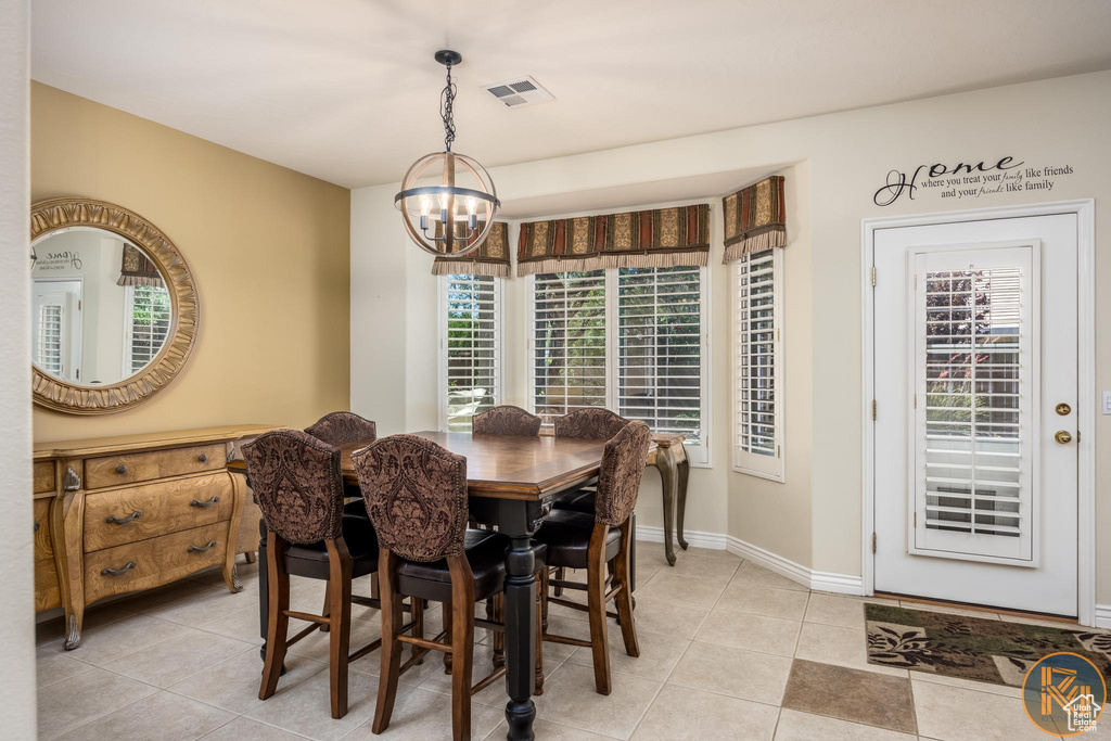 Dining room with a notable chandelier and light tile flooring