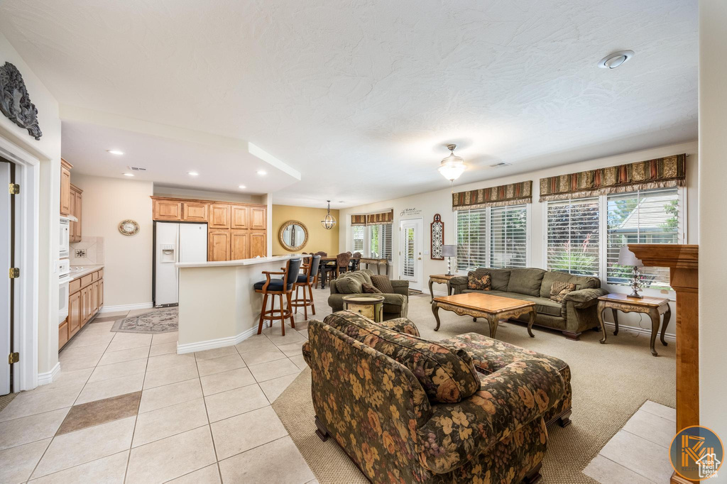 Living room with ceiling fan and light tile floors