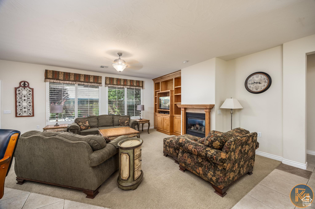 Living room with ceiling fan and light tile flooring