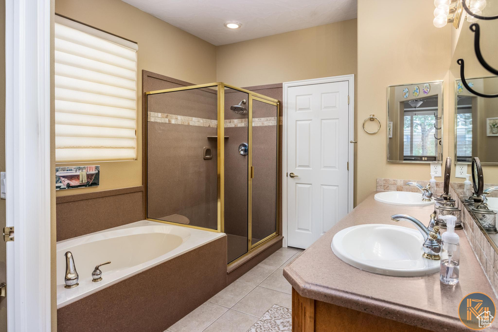 Bathroom featuring large vanity, tile flooring, double sink, and plus walk in shower