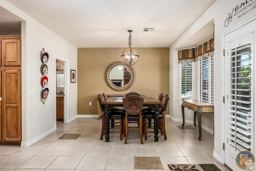 Dining space with an inviting chandelier and light tile floors