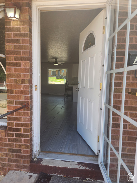 View of exterior entry with ceiling fan