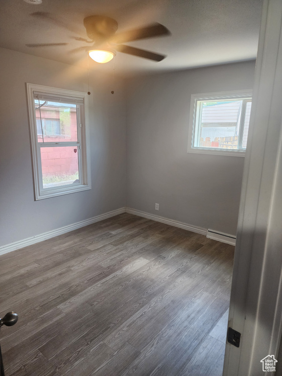 Unfurnished room with hardwood / wood-style flooring, a baseboard radiator, and ceiling fan