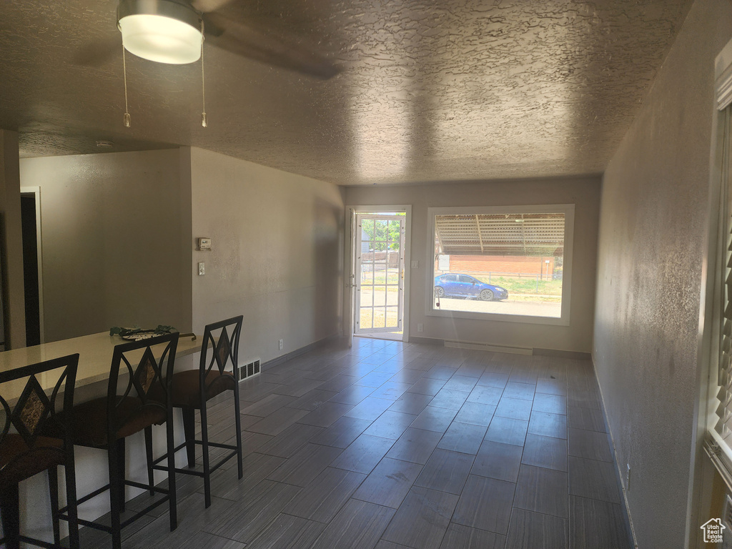 Dining room featuring ceiling fan and a textured ceiling