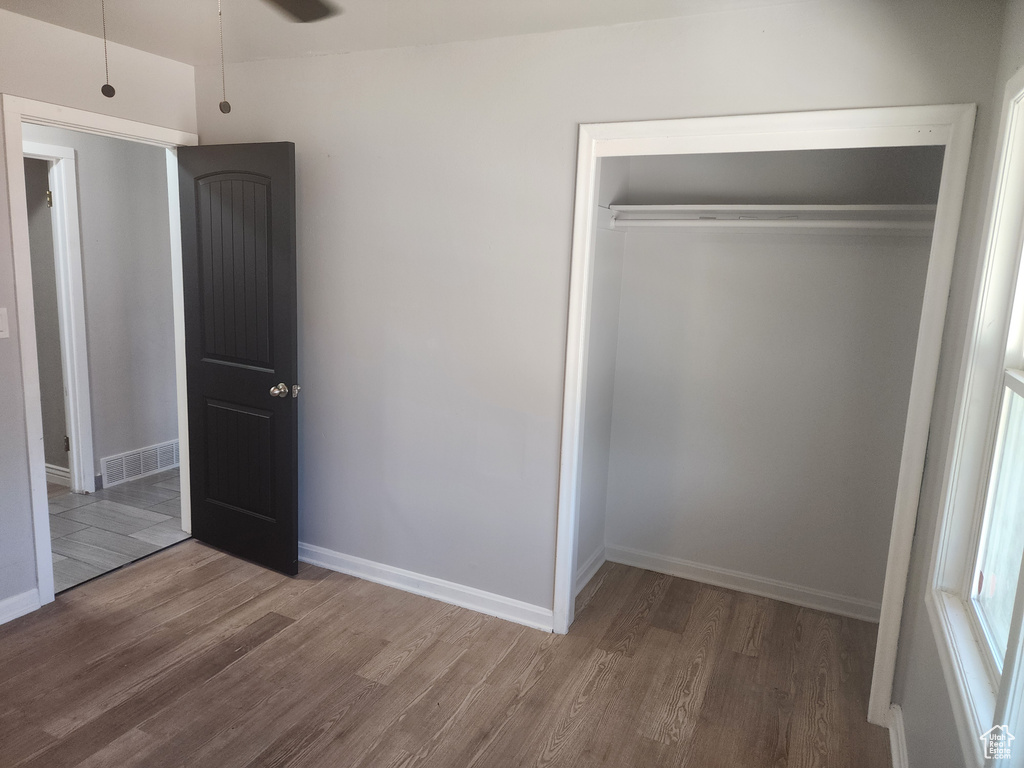 Unfurnished bedroom with a closet and hardwood / wood-style floors