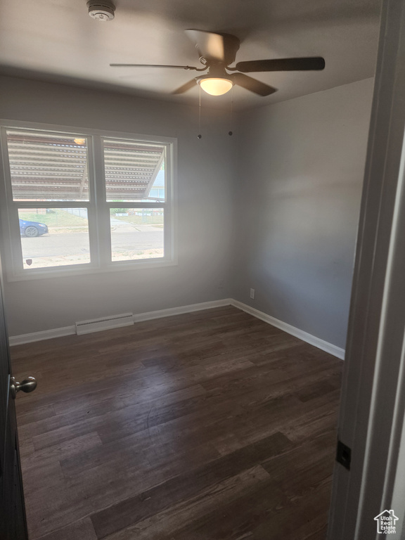 Spare room with dark hardwood / wood-style floors and ceiling fan