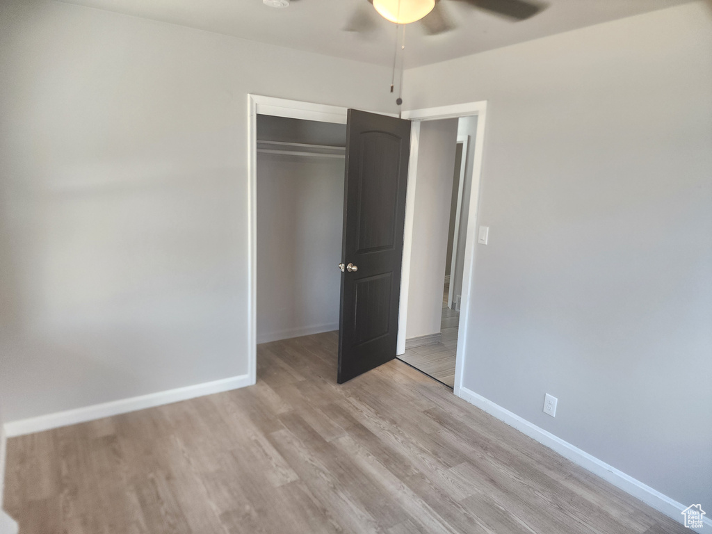 Unfurnished bedroom featuring ceiling fan, a closet, and light hardwood / wood-style floors