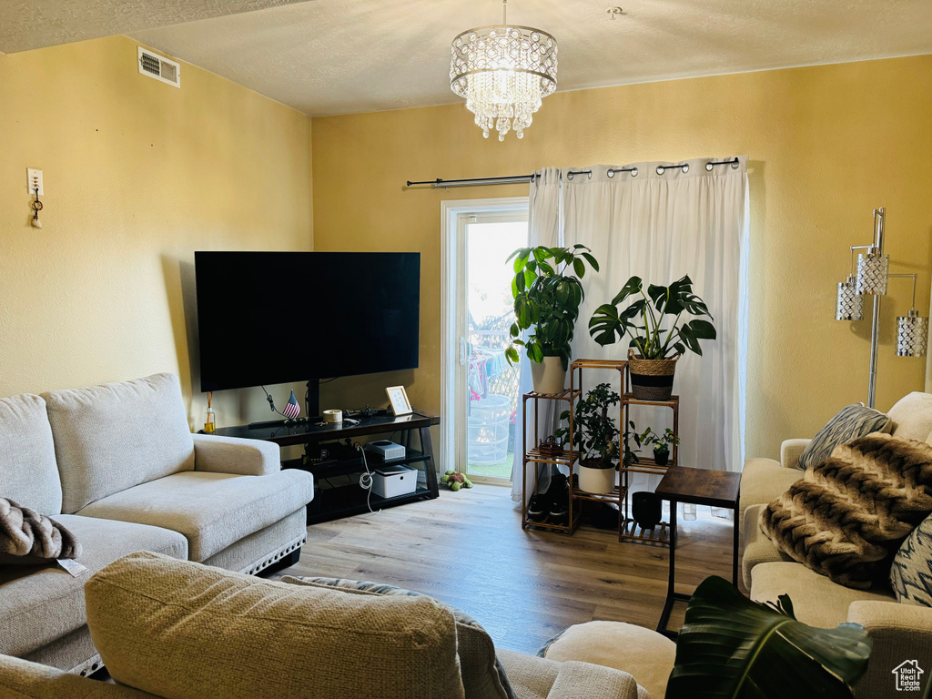 Living room featuring an inviting chandelier and hardwood / wood-style floors