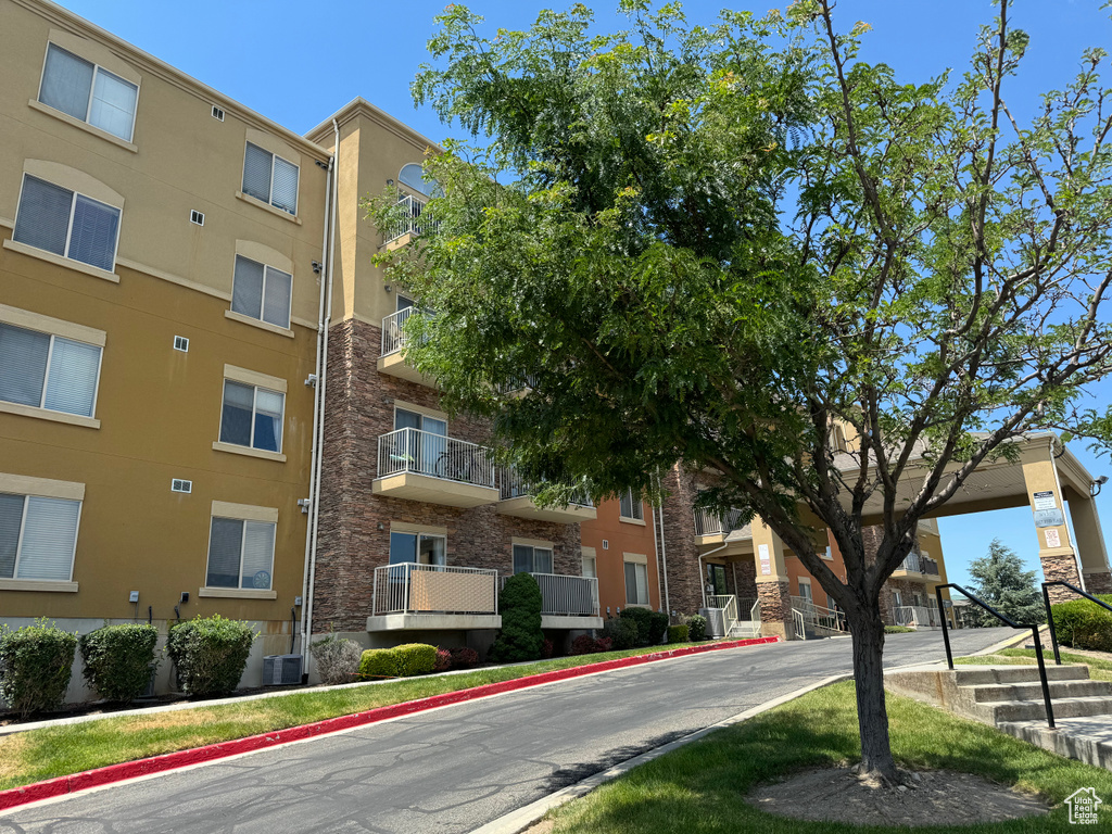 View of building exterior featuring central AC unit