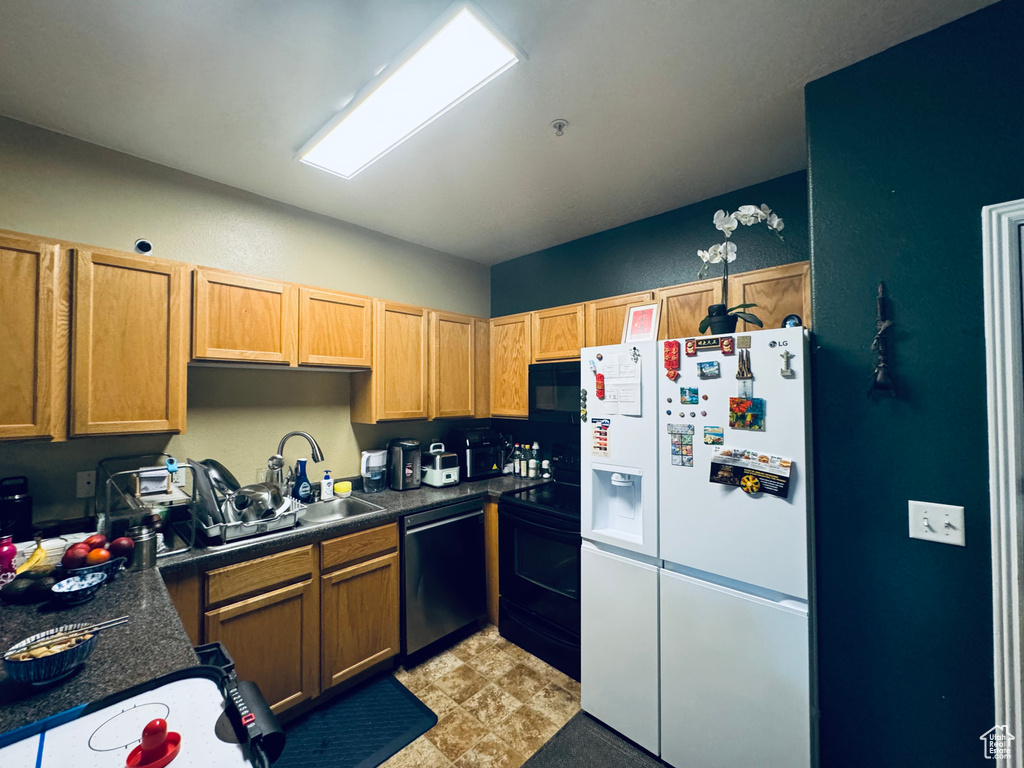 Kitchen with white refrigerator with ice dispenser, dishwasher, light tile floors, sink, and range with electric stovetop