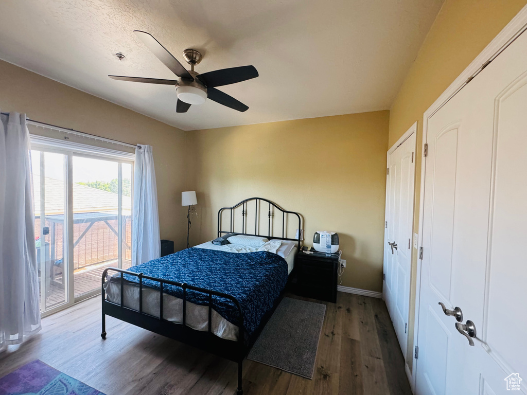 Bedroom with access to exterior, ceiling fan, and hardwood / wood-style floors