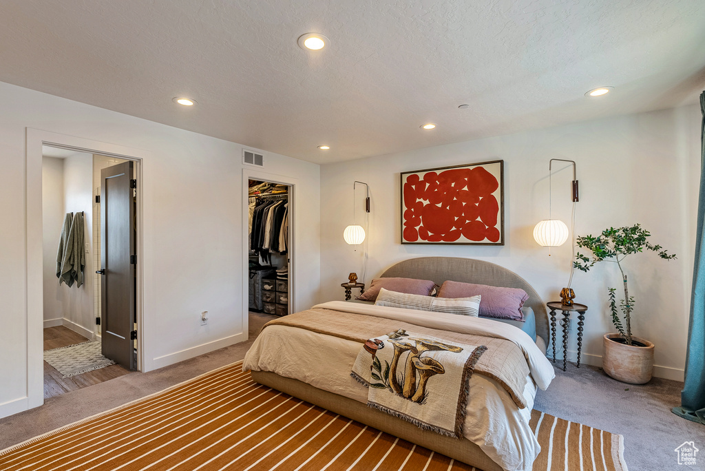 Carpeted bedroom with a closet and a walk in closet