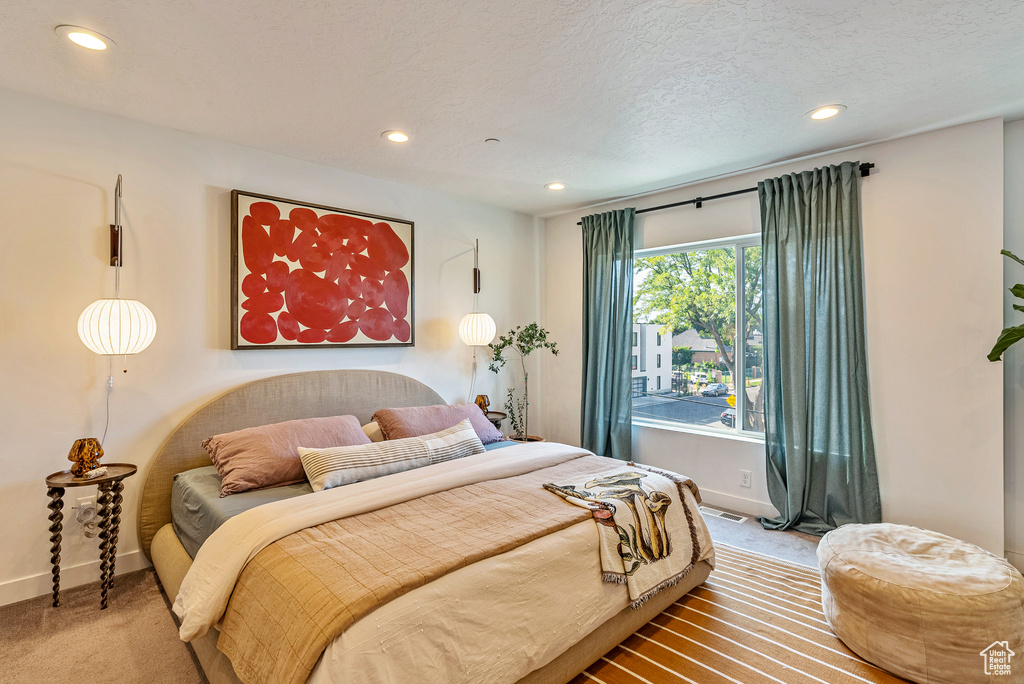 Bedroom with a textured ceiling and wood-type flooring