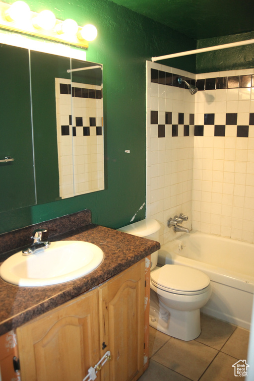 Full bathroom with tile floors, tiled shower / bath, vanity, and toilet