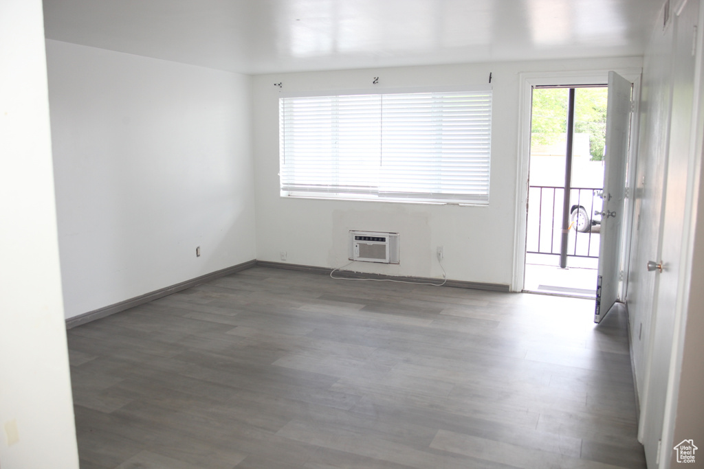 Spare room with a wall mounted air conditioner and hardwood / wood-style floors