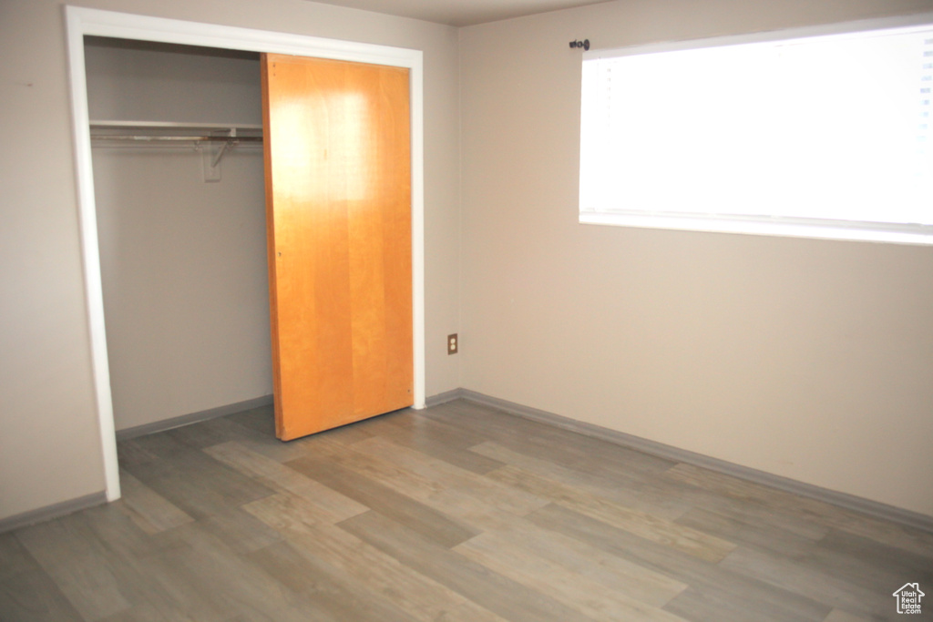 Unfurnished bedroom with a closet and hardwood / wood-style flooring