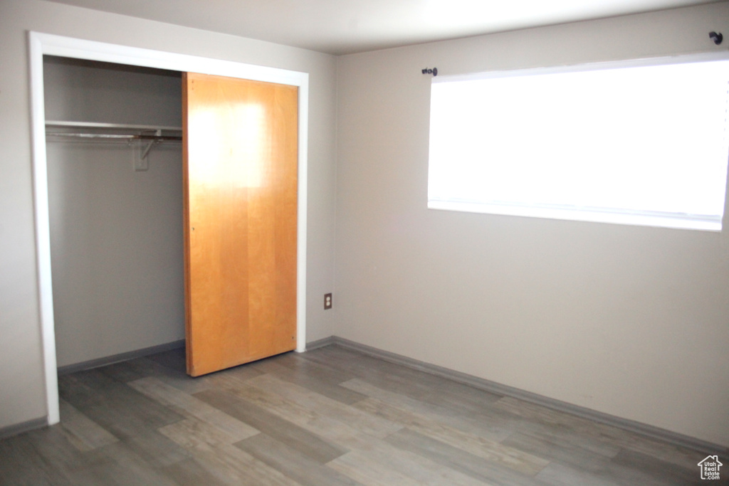 Unfurnished bedroom featuring a closet and hardwood / wood-style flooring