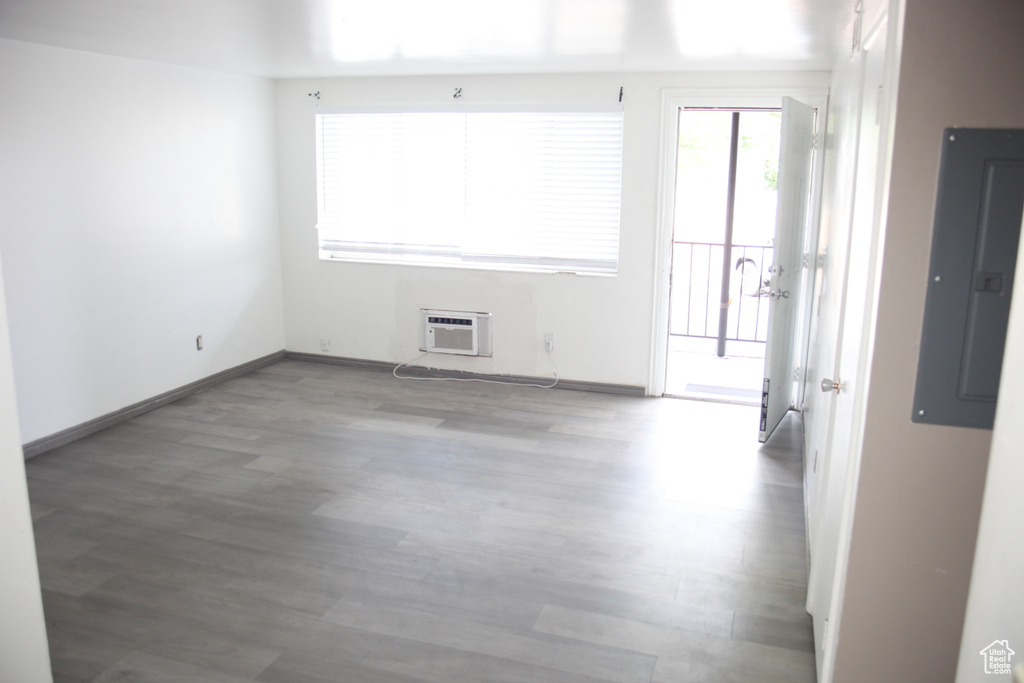 Unfurnished room featuring a wall unit AC and hardwood / wood-style flooring