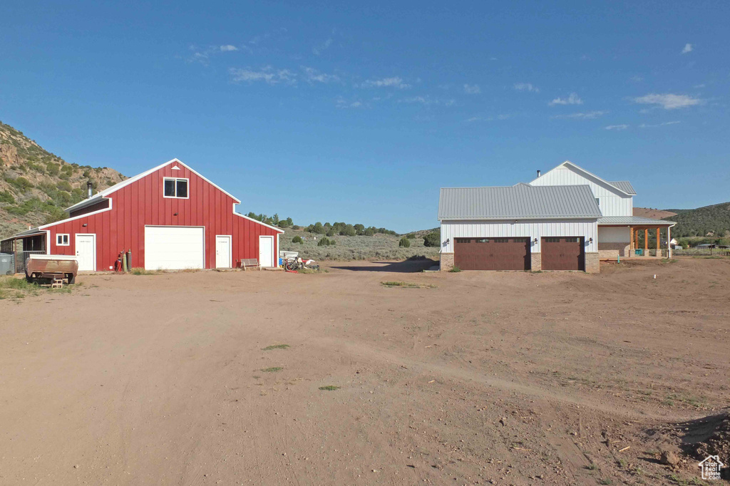 View of yard with an outdoor structure, a mountain view, and a garage