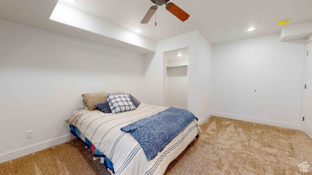 Bedroom with ceiling fan, a closet, carpet flooring, and a spacious closet