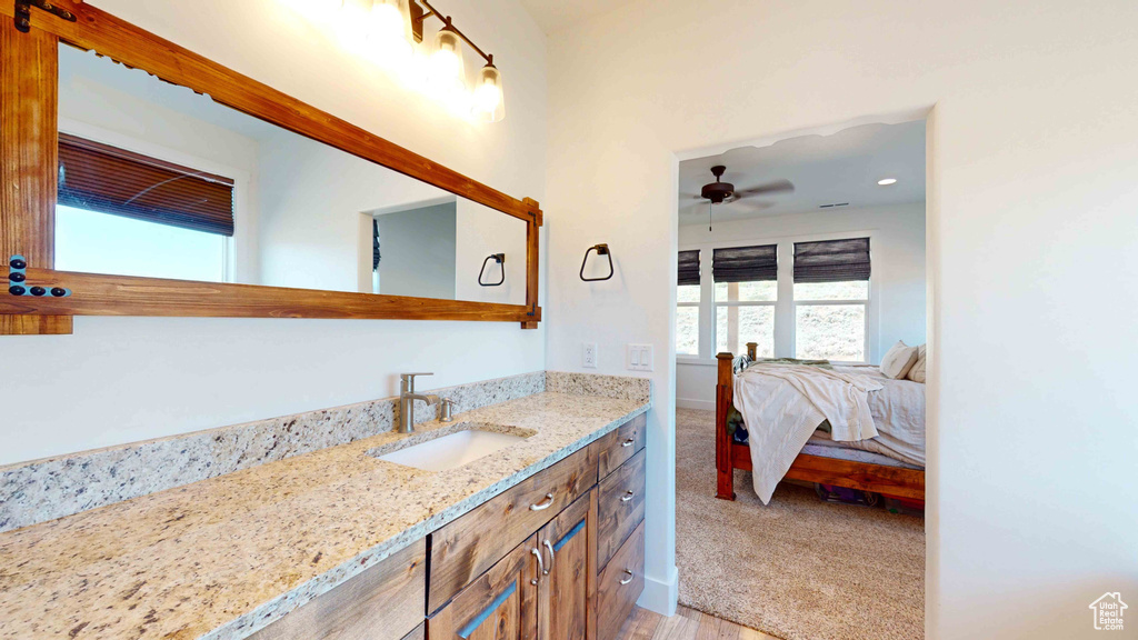 Bathroom with ceiling fan and vanity with extensive cabinet space