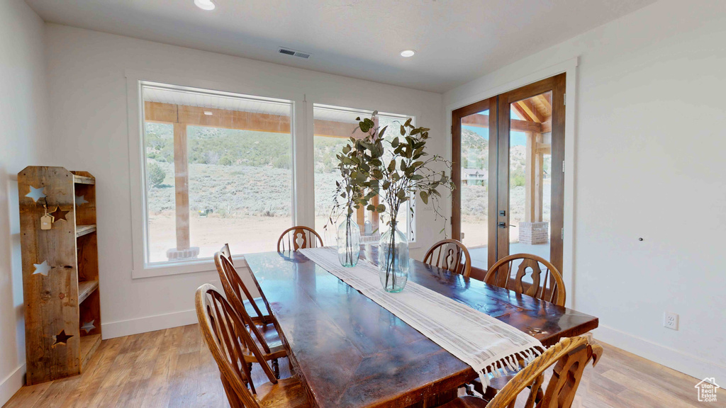 Dining area with light hardwood / wood-style flooring and french doors