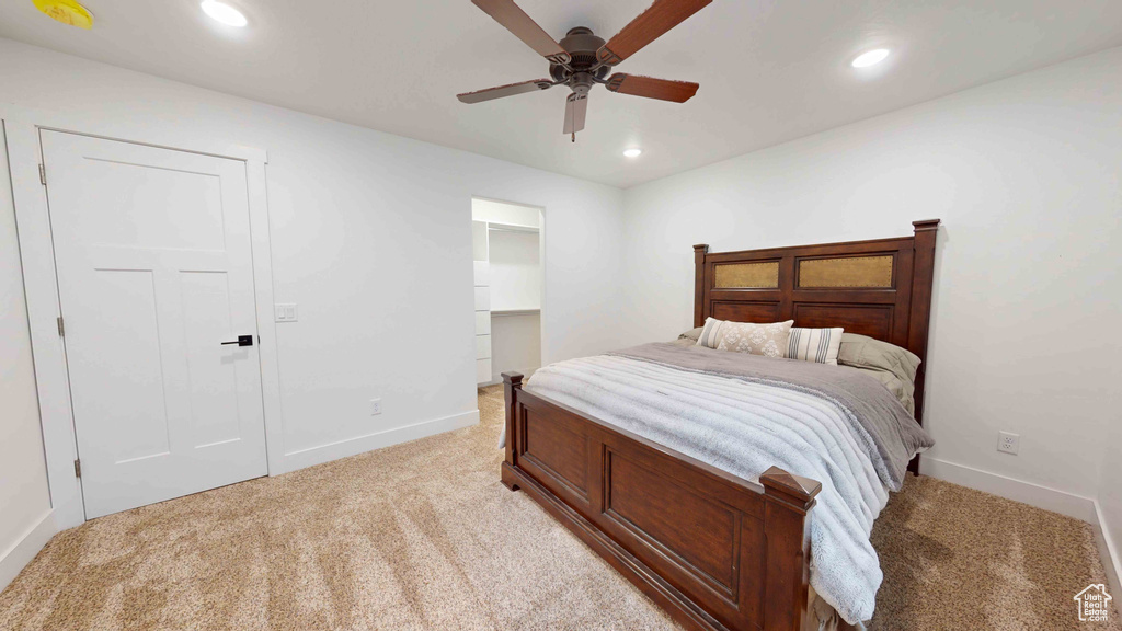 Carpeted bedroom with a closet and ceiling fan