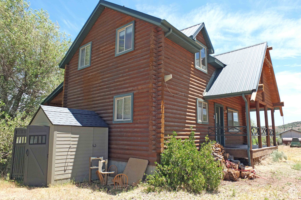 View of side of home with a storage shed
