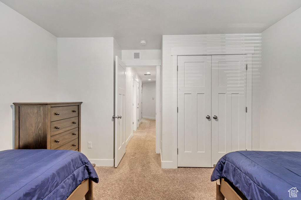 Bedroom with a closet and light carpet