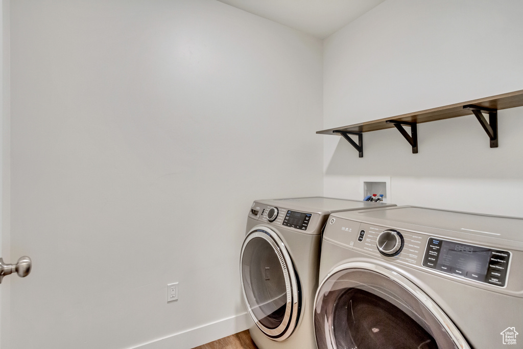 Laundry area with hookup for a washing machine, separate washer and dryer, and wood-type flooring