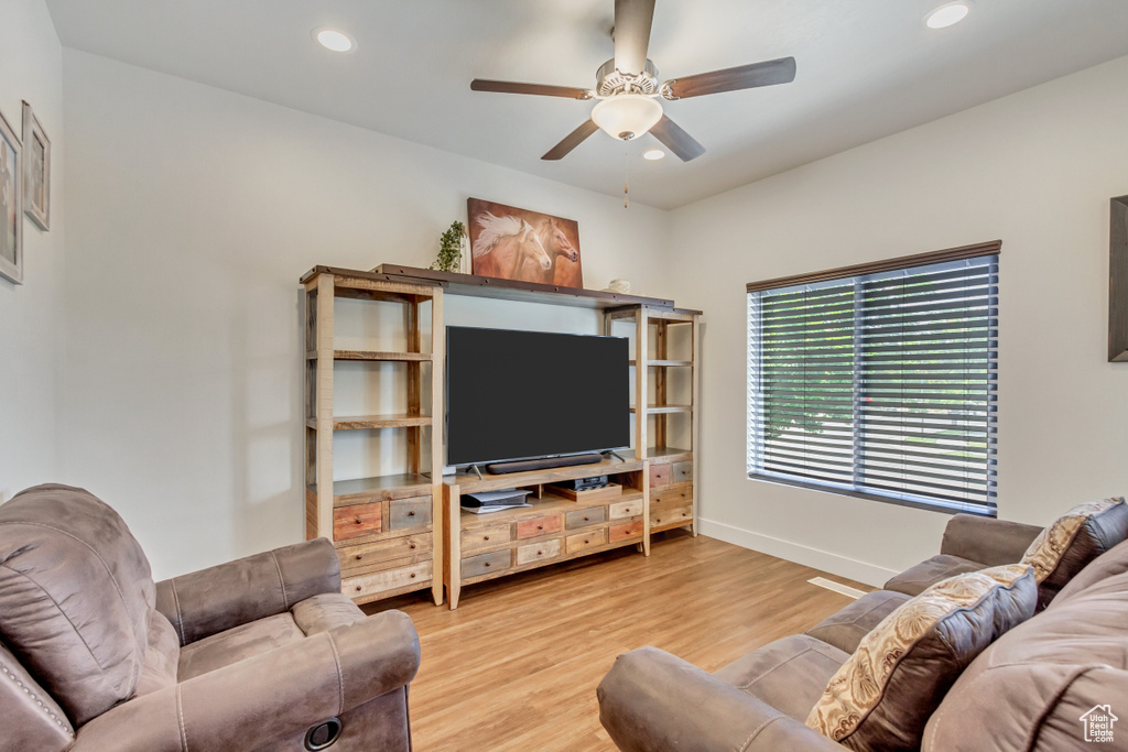 Living room with ceiling fan and light hardwood / wood-style flooring