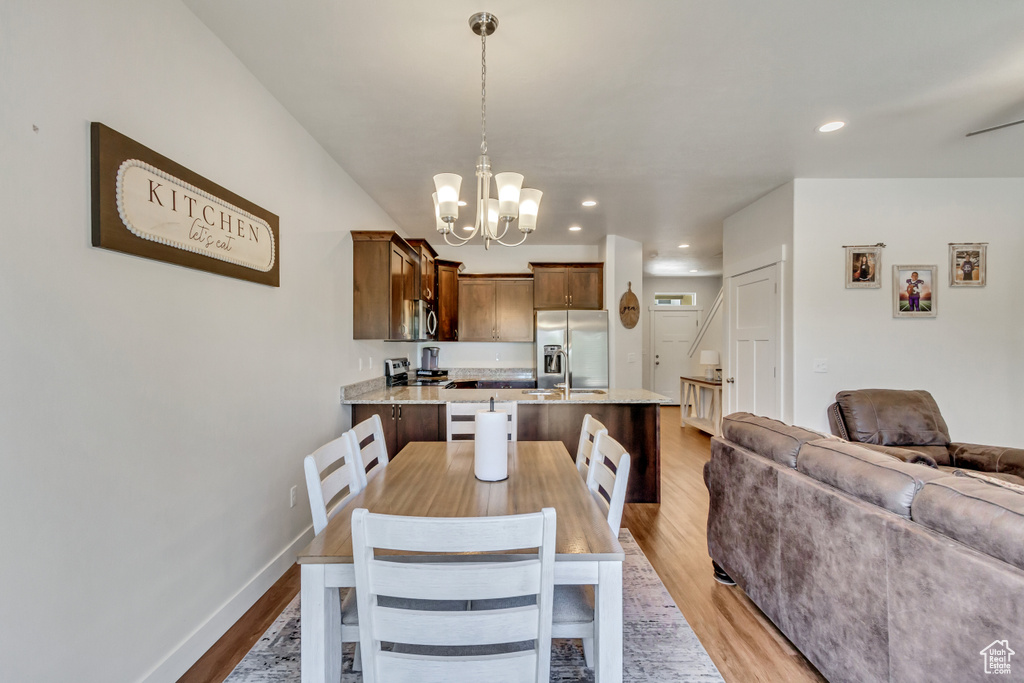 Dining space featuring wood-type flooring and an inviting chandelier