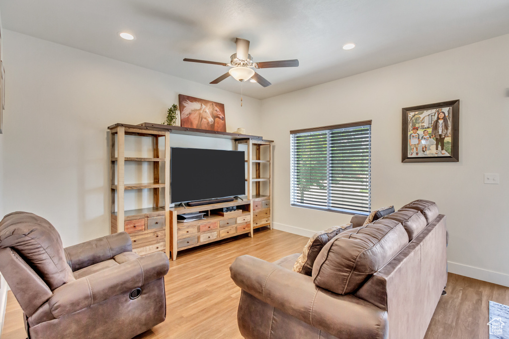 Living room featuring ceiling fan and light hardwood / wood-style flooring