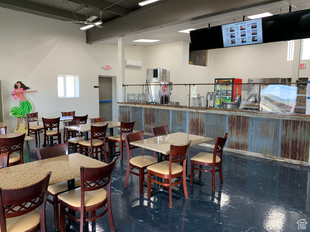 Interior space featuring a high ceiling, a wall mounted AC, and track lighting