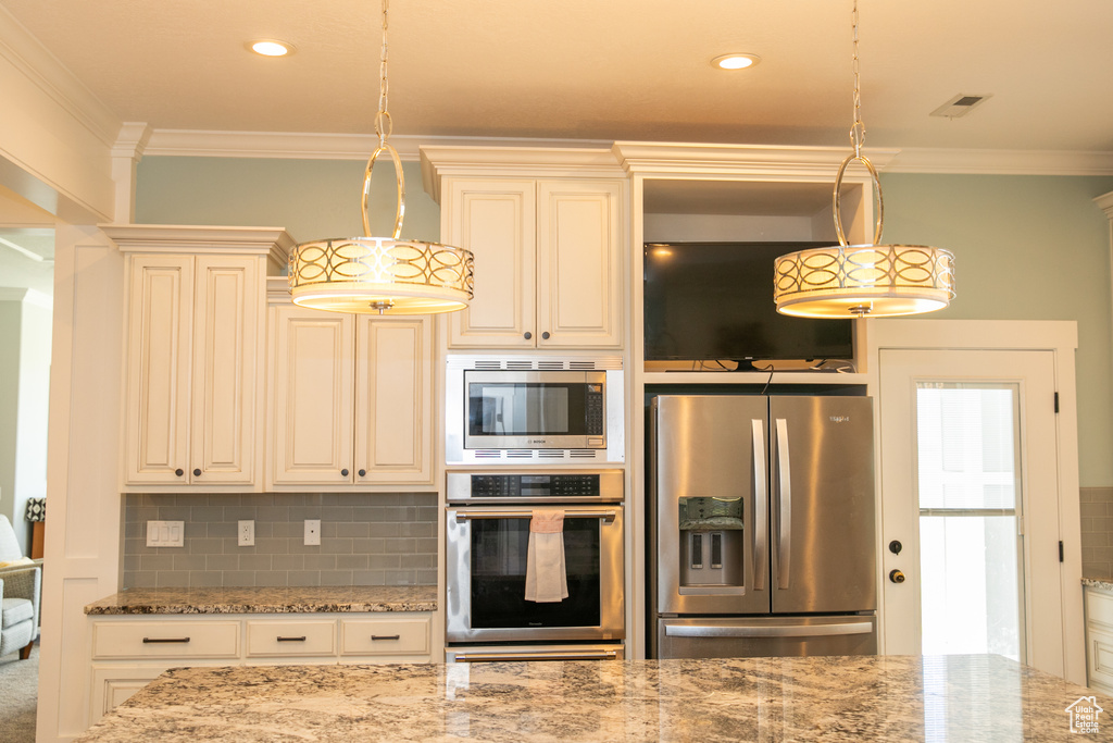 Kitchen with crown molding, stainless steel appliances, light stone countertops, decorative backsplash, and pendant lighting