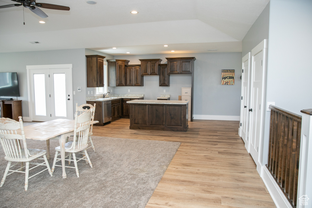 Kitchen featuring sink, dark brown cabinetry, light wood-type flooring, a center island, and ceiling fan