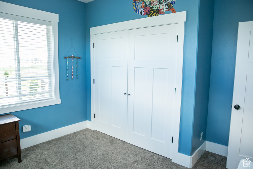 Unfurnished bedroom featuring a closet, multiple windows, and carpet