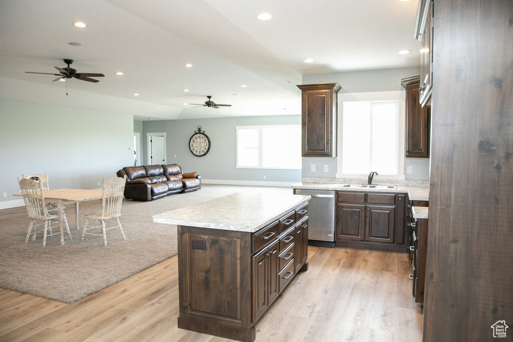 Kitchen featuring stainless steel dishwasher, ceiling fan, a center island, dark brown cabinetry, and light hardwood / wood-style floors