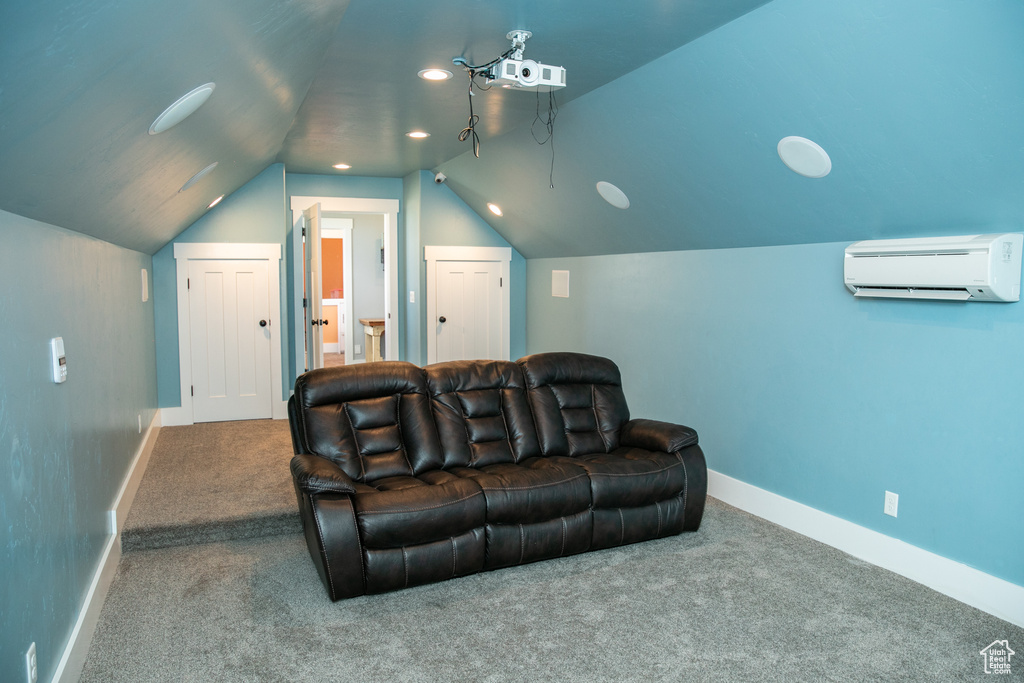 Carpeted cinema with a wall unit AC and lofted ceiling